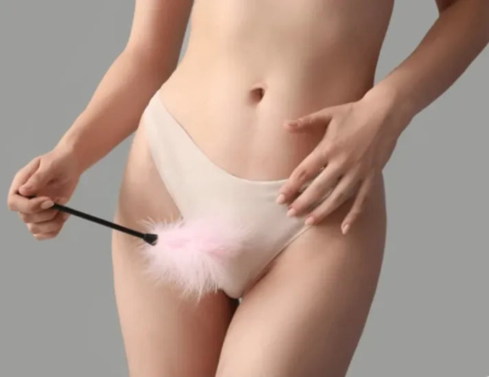 Feather Tickler teasing: A woman in white panties gently strokes her lower body with a pink feather tickler