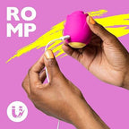 Woman holding a Rose Vibrator for Women, charging with a white cable against a vibrant pink background.