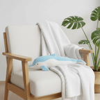 Dolphin Plush Thrusting Dildo Vibrator resting on a chair with a soft blanket, perfect for women.