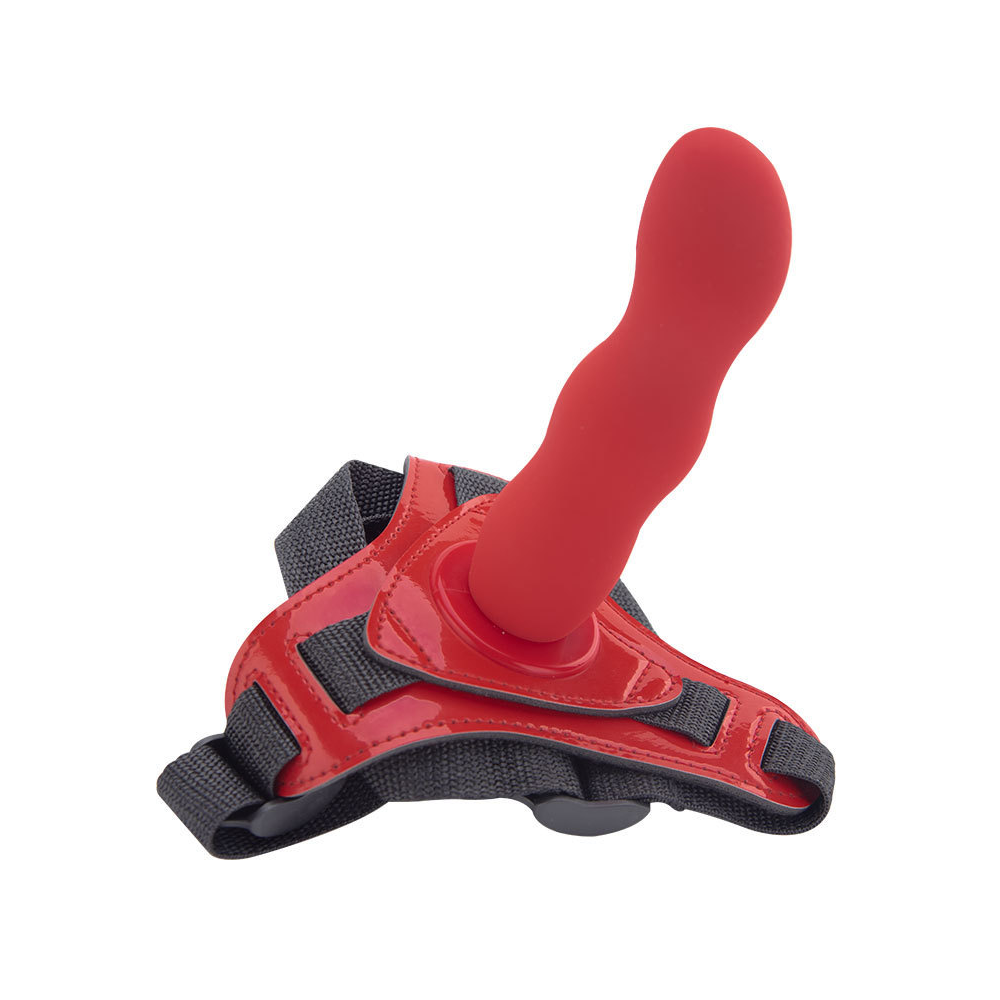 Red adjustable strap-on harness with textured attachment on a white background