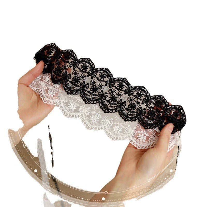 Black and white floral lace tie-on blindfolds displayed by hand