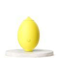 Yellow lemon-shaped clitoral suction vibrator on white display stand