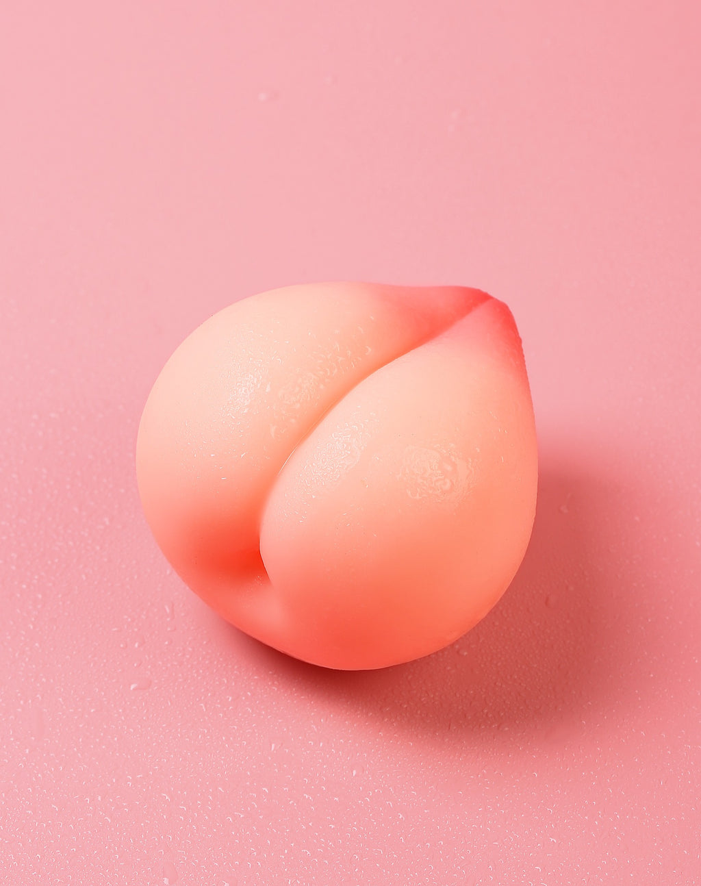 Angled view of peach-shaped soft manual male masturbator