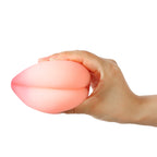Hand holding peach-shaped compact TPE male masturbator