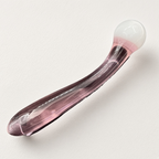 Angled view of curved pink glass dildo with rounded white ball head