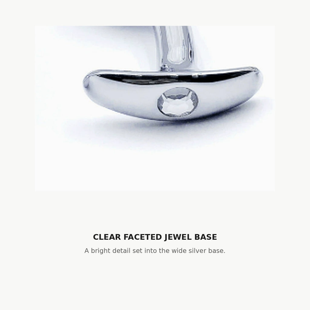 Close-up of the clear faceted jewel set into the wide silver base of the curved aluminum anal plug