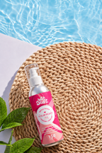 Wet Stuff Strawberry Edible Water Based Lube bottle on a woven mat near a pool, perfect for oral play.