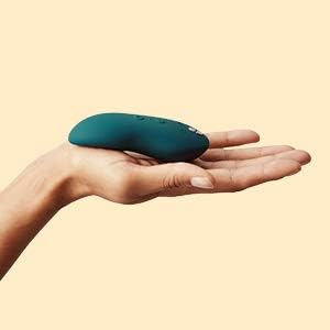 X Lying Vibrator in a hand, soft green design perfect for clitoral stimulation and ergonomic fit.