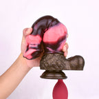 N5092 marbled silicone squirting dildo shown bent by hand to demonstrate flexibility and scale