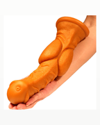 Orange equine-style textured silicone fantasy dildo shown across a forearm for scale