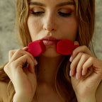 Model holding a red silicone lip mouth opener gag near her lips