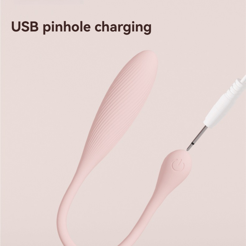 USB pinhole charging cable beside the pink mini vibrator control button.